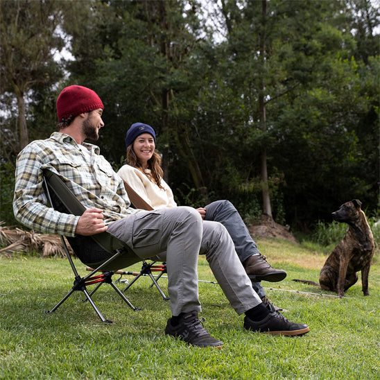 deux amoureux de la nature avec leur chien installés dans une chaise camping