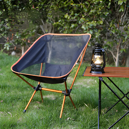 chaise-de-camping-sur-gazon-pres-de-table-et-lanterne