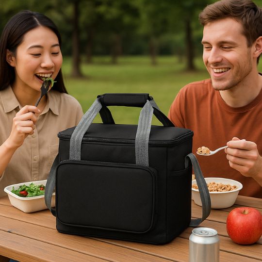 un homme et une femme qui mange un repas frais grâce a leur glaciere souple noir posé sur la table