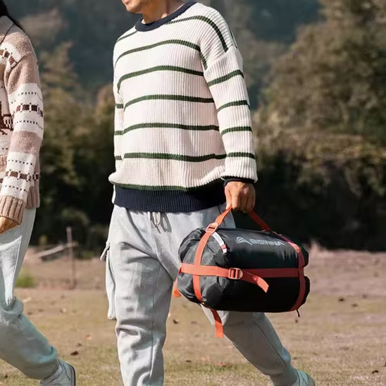 homme qui transporte son sac de couchage a son camping