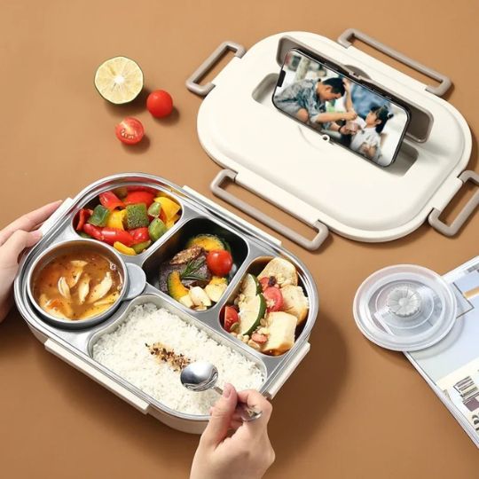 personne qui mange son repas dans sa lunch box isotherme en écoutant une série avec le support inclu