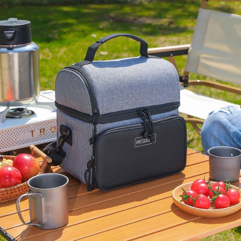 un sac glacière noir et gris sur une table de camping