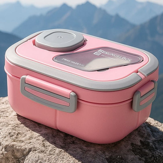 présentation d'un boite à repas rose sur un rocher au sommet d'une montagne