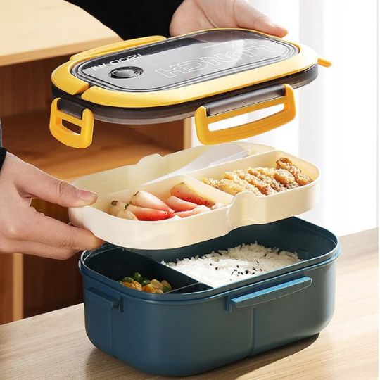 une personne qui ouvre une boite repas en plusieurs compartiments