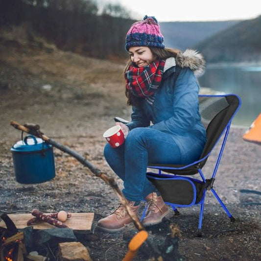 chaise-de-camping-bleu-fonce-avec-femme-pres-de-feu