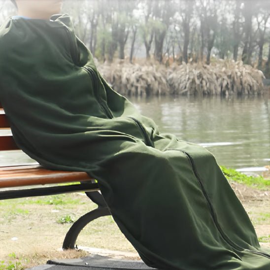 homme-assis-sur-une-chaise-dehors-dans-son-drap-pour-sac-de-couchage-vert