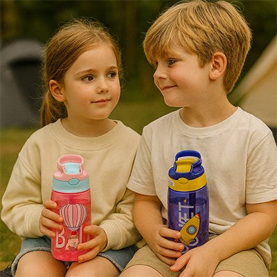 enfant assis avec une gourde enfant paille dans leur mains
