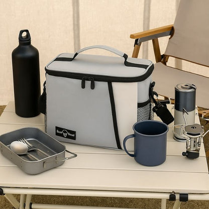 une glacière souple gris sur une table camping avec d'autre accessoire repas