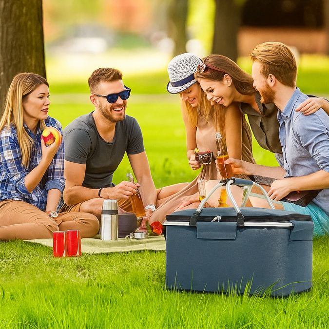 amis en pique-nique dégustant un repas frais avec leur glaciere souple bleu