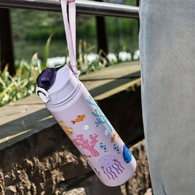 enfant qui tient sa gourde par la anse en extérieur