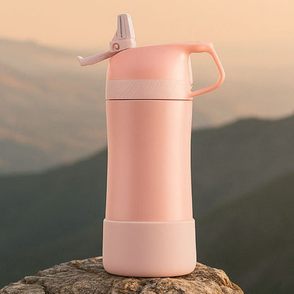 présentation d'une gourde enfant isotherme rose sur un rocher au sommet d'une montagne