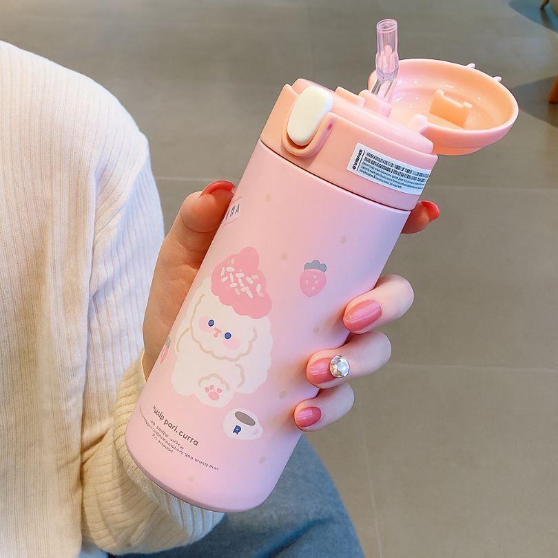un gourde isotherme enfant rose dans la main d'une femme
