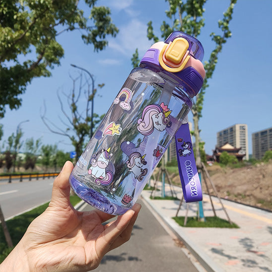 personne qui montre a la caméra une gourde paille enfant violet avec motifs de licorne