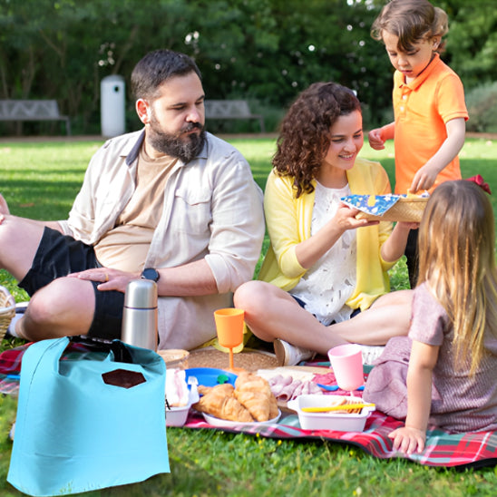 famille-avec-enfant-lors-de-pique-nique-avec-un-lunch-bag-bleu