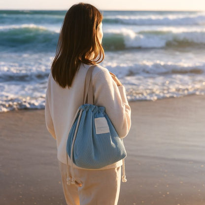 femme sur le bord de la mer avec son lunch bag bleu en velours côtelé