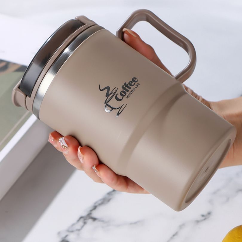 mug thermo brun dans a main d'une femme