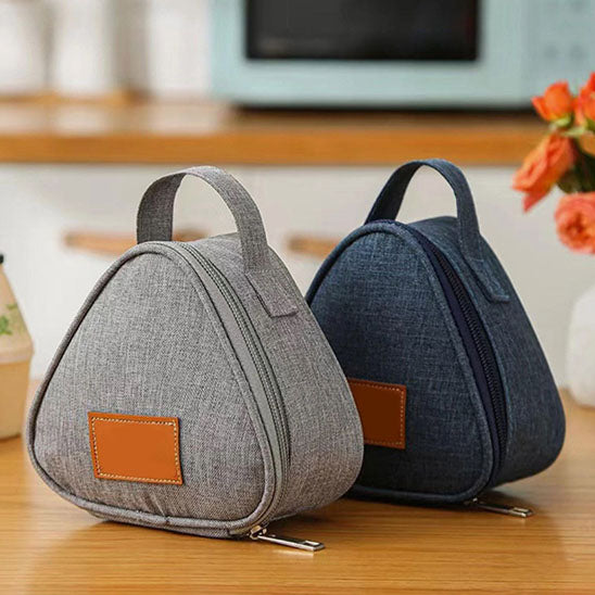 deux petit sac isotherme, un bleu, l'autre gris, cote a cote sur une table de cuisine