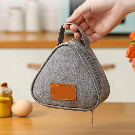 femme qui tient un petit sac isotherme triangulaire grispar la anse