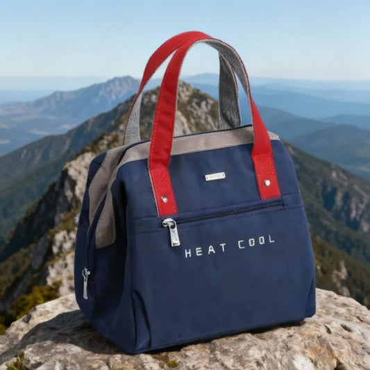 présentation d'un sac à déjeuner bleu sur un rocher au sommet d'une montagne