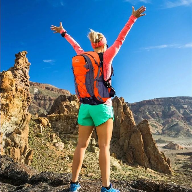 femme-heureuse-en-haut-dune-montagne-avec-un-sac-a-dos-40l-sur-son-dos