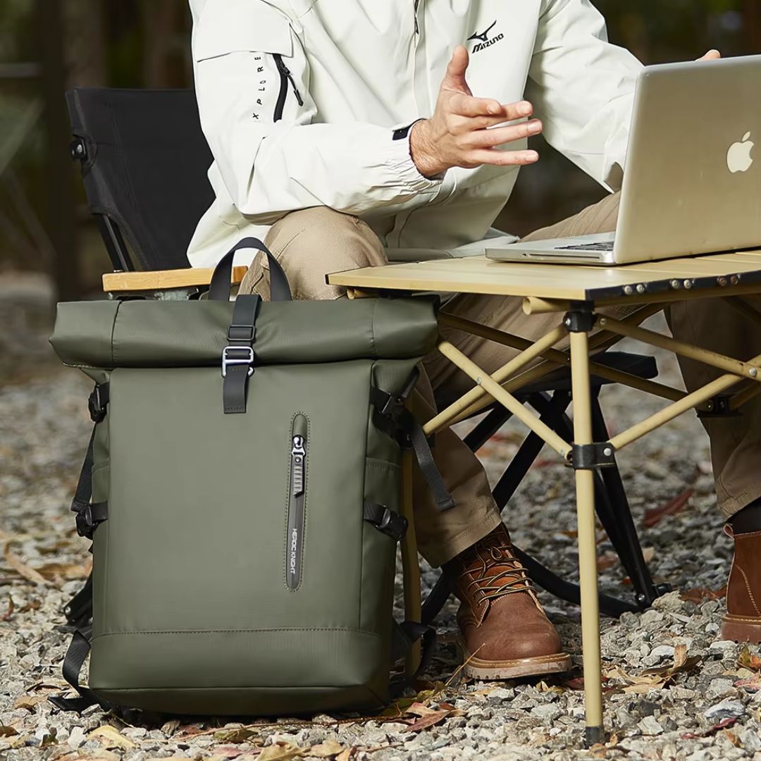 une-personne-travaillant-à-lordinateur-en-nature-avec-un-sac-a-dos-etanche-au-pied