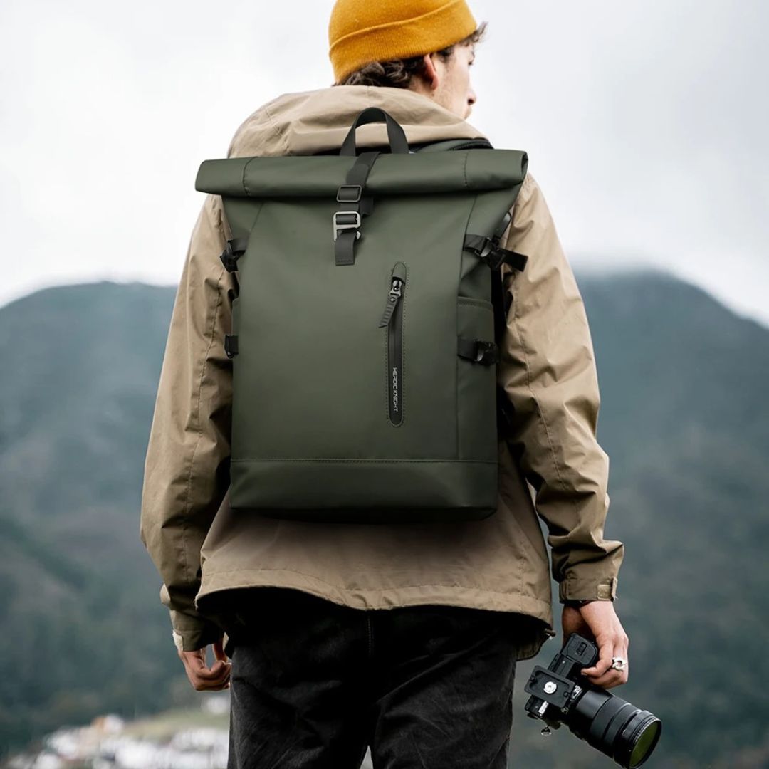 un-photographe-regardant-le-paysage-avec-son-sac-a-dos-etanche-vert