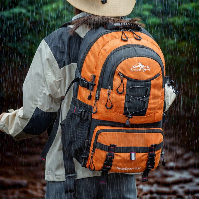 femme-qui-porte-un-sac-à-dos-imperméable-lors-dune-pluie-intense