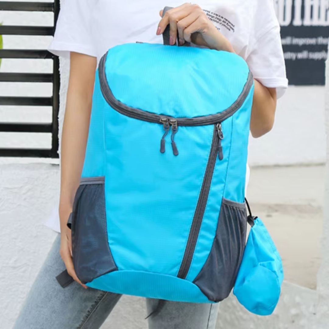 sac-à-dos-pliable-bleu-tenu-par-une-femme