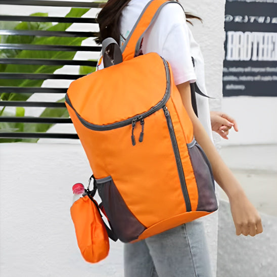 Femme-portant-un-sac-à-dos-pliable-orange-de-randonnée