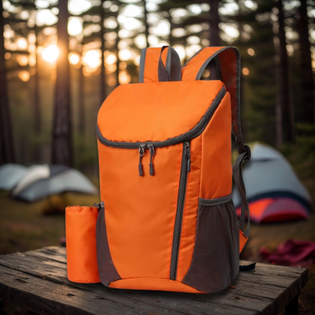 sac-à-dos-pliable-orange-sur-une-table-de-camping