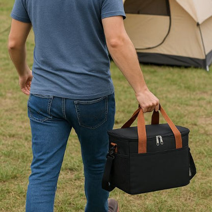 homme portant un sac glaciere noir dans sa main en se dirigeant vers sa tente