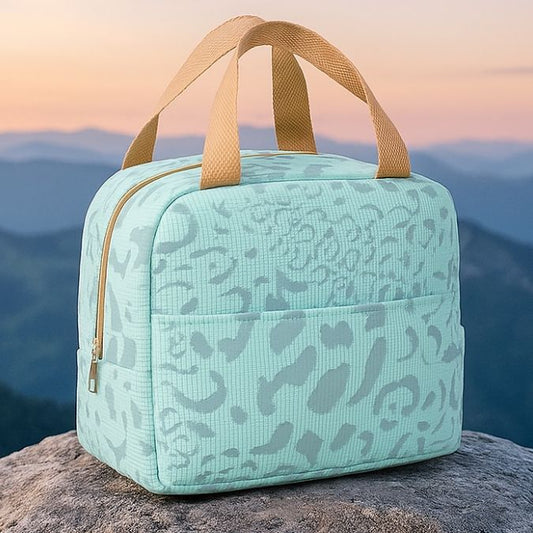 présentation d'un sac isotherme bleu sur une roche au sommet d'une montagne