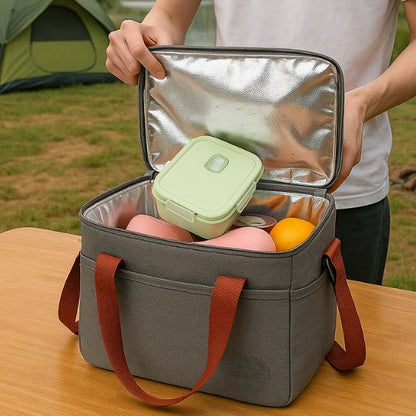 une femme qui ouvre un sac isotherme repas gris en camping. le sac est plein de lunch box