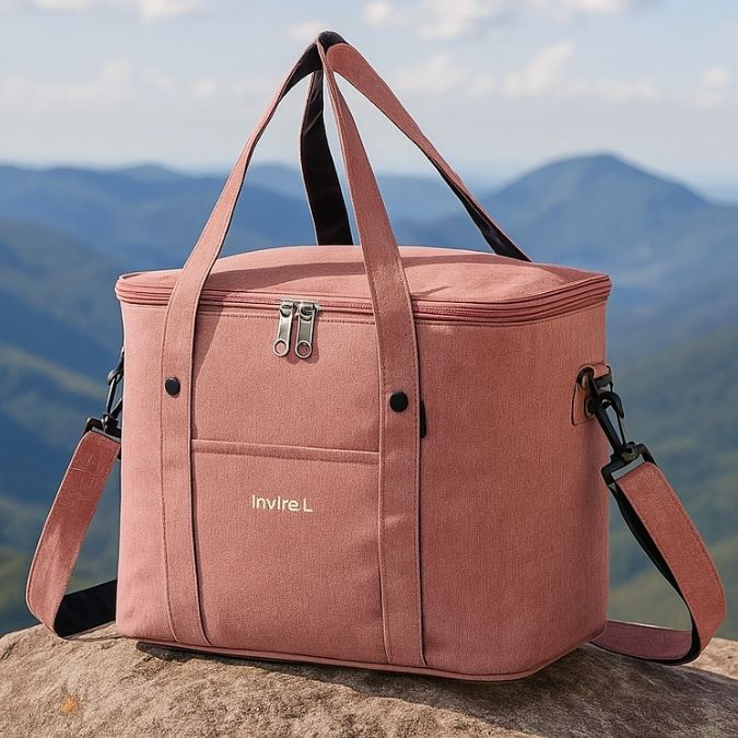 présentation d'un sac pique nique rose sur une roche en plein air au sommet d'une montagne