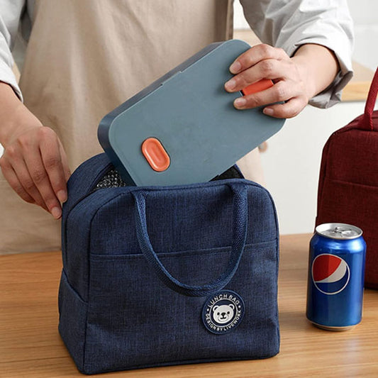 homme qui entre un lunch box dans un sac repas isotherme pour le garder au frais