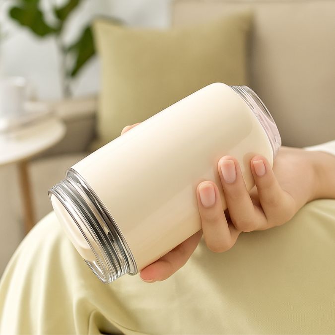 tasse isotherme blanche dans la main