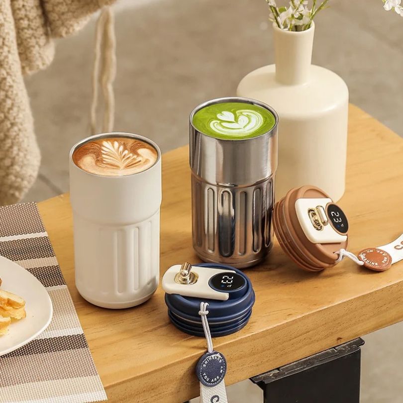 2 tasses thermos sur un comptoir en ois