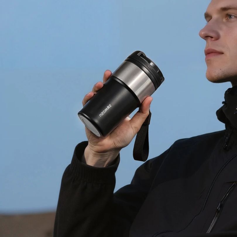homme qui boit cafe de son thermos
