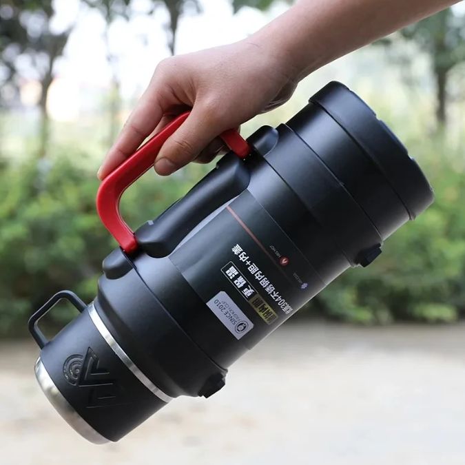 main qui tient par la anse un thermos flask mug